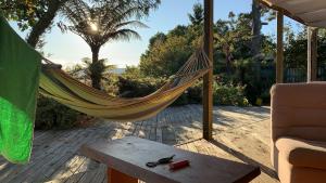 a hammock on a patio with a table and a chair at Luigi's home in Rotorua