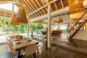 ein Esszimmer mit Tisch und Stühlen in der Unterkunft Oma Villa - A tropical sanctuary of Seminyak in Seminyak