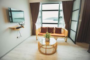 een woonkamer met een bank en een tafel bij TF Sunset Ocean View Homestay - Jesselton Quay in Kota Kinabalu
