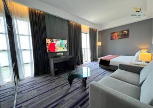 a hotel room with a bed and a couch at Bahang Bay Hotel in Batu Ferringhi