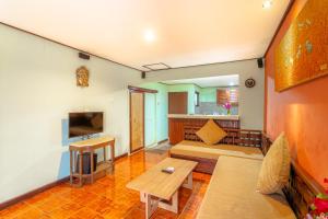 sala de estar con sofá y TV en Pacung Indah Hotel & Restaurant by ecommerceloka en Bedugul