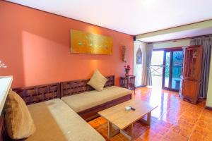 een woonkamer met een bank en een tafel bij Pacung Indah Hotel & Restaurant by ecommerceloka in Bedugul
