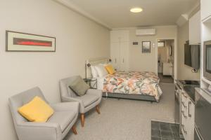 a bedroom with a bed and a couch and a chair at Smith House in Whanganui