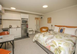 a bedroom with a large bed and a kitchen at Smith House in Whanganui