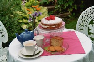 a table with a cake and a cup of coffee at Pennycroft Guest House in Kettlewell