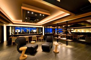 a restaurant with a bar with chairs and tables at THE CHELSEA BREATH in Takamatsu