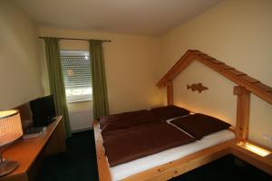 a bedroom with a bed and a desk with a computer at Fischerstüberl in Gaishofen