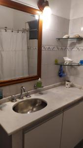 eine Badezimmertheke mit einem Waschbecken und einem Spiegel in der Unterkunft La Pirca Rosada in San Fernando del Valle de Catamarca