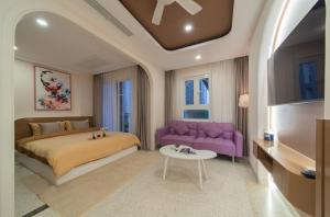 um quarto com uma cama e um sofá roxo em Pavillon Garden Hotel & Spa Nha Trang em Nha Trang