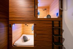 a room with two bunk beds and a ladder at Jpod Capsule Hotel in Kota Kinabalu