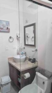 a bathroom with a sink and a toilet and a mirror at Casa Mauricio in La Paz