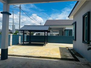 a house with a blue fence and a roof with a shelter at Villa Pool Kepala Batas in Kampong Hilir