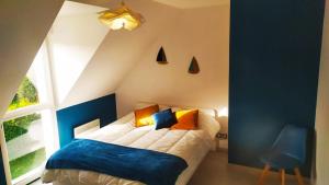 1 dormitorio con cama y ventana en Agréable maison moderne, entre campagne et mer !, en Dozulé