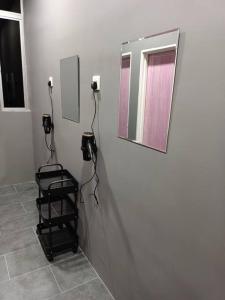 a bathroom with a mirror on the wall and a stool at Impian Stay 0.1 Townhouse with 3 bedrooms. in Kuah