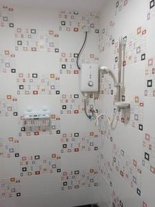 a bathroom with a wall covered in many tiles at Impian Stay 0.1 Townhouse with 3 bedrooms. in Kuah