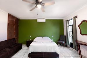 Dormitorio verde con cama y sofá en Habitación privada en el centro de Tequila en Tequila