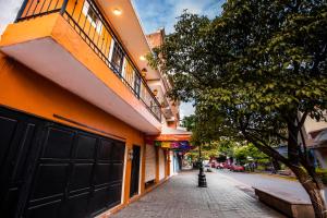 a street with an orange building and a tree at Habitación privada en el centro de Tequila in Tequila