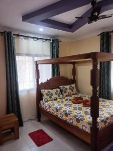 a bedroom with a bed and a window with curtains at Coasterian Apartment in Mombasa