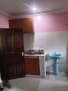 Il comprend une petite cuisine équipée d'une cuisinière et d'un évier. dans l'établissement Coasterian Apartment, à Mombasa