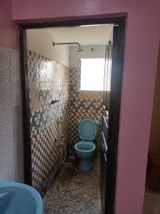 a bathroom with a blue toilet and a window at Coasterian Apartment in Mombasa