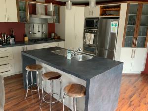 a kitchen with a island with a sink and two bar stools at Large stand alone home with two living areas. in Taupo