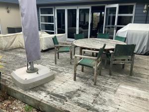 a patio with a table and chairs on a deck at Large stand alone home with two living areas. in Taupo