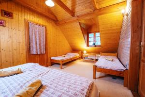 sypialnia z 2 łóżkami w drewnianym domku w obiekcie Andělský Dvůr w mieście Světce