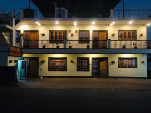 a large white building with many windows at night at IMPERIAL COTTAGE, HILL BUNK OOTY in Ooty