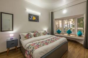 Un dormitorio con una cama grande y una ventana en StayVista at Pines & Spruce - Exclusive getaway, en Lansdowne