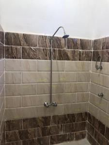 um chuveiro na casa de banho com uma parede de pedra em Olive Garden House em ‘Izbat Zaydān