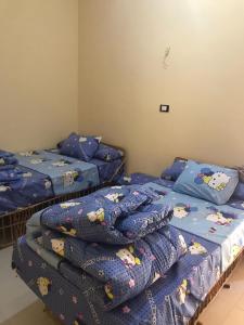 een slaapkamer met 2 aparte bedden en Hello Kitty dekens bij Olive Garden House in ‘Izbat Zaydān