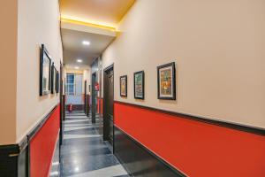um corredor com paredes vermelhas e brancas e uma parede vermelha em FabHotel Pine Tree em Noida