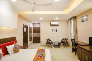 um quarto com uma cama, uma secretária e cadeiras em FabHotel Pine Tree em Noida