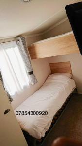 a bunk bed in a room with a window at Haven Haggerston castle caravan hire in Cheswick