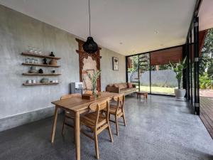 una sala da pranzo con tavolo e sedie in legno di Villa Keliki a Munggu