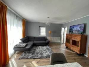 un soggiorno con divano e TV a schermo piatto di Tiberiu Ricci Apartament a Sibiu