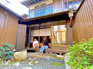 京都市にあるゲストハウス 木音の家の玄関に座る二人の女性