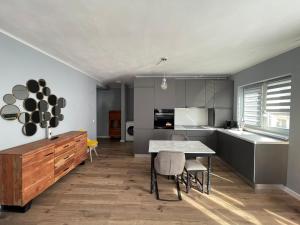 una cucina con tavolo e sedie in una stanza di Tiberiu Ricci Apartament a Sibiu