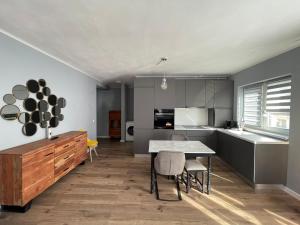 a kitchen with a table and chairs in a room at Tiberiu Ricci Apartament in Sibiu