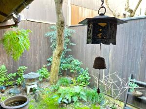 a garden with a lantern hanging from a fence at Guesthouse Kioto in Kyoto