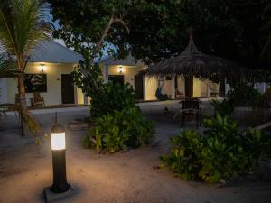 une bougie devant une maison la nuit dans l'établissement Clouds Beach Retreat Laamu Gan, à Gan