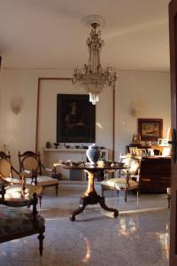 - un salon avec un lustre, une table et des chaises dans l'établissement La casa di Bedelia, à Capodimonte