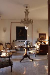 sala de estar con lámpara de araña, mesa y sillas en La casa di Bedelia, en Capodimonte
