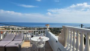 balkon ze stołem i krzesłami oraz oceanem w obiekcie Room in Apartment - Spacious Room in Creta for 3 people, with Ac, Swimming Pool and Nature w mieście Hersonissos +17 zdjęć