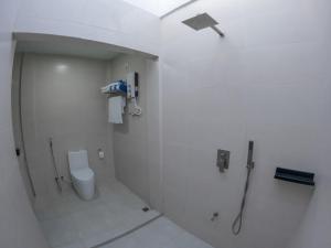 a white bathroom with a shower and a toilet at Clouds Beach Retreat Laamu Gan in Gan