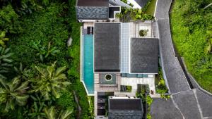 een uitzicht op een huis met een zwembad bij Villa Three Little Birds by BaliSuperHost in Ubud