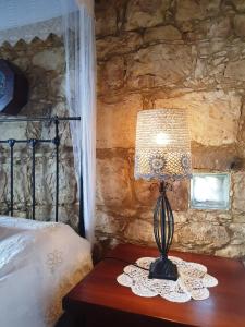 a lamp sitting on a table next to a bed at HideAway Lasa in Lasa