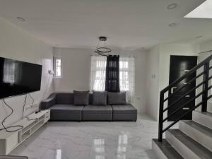 a living room with a couch and a flat screen tv at JRLB PLACE - Accommodation in Concepcion, Tarlac in Concepcion