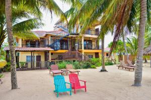 un edificio con palmeras y sillas en la playa en Buttonwood Belize, en Hopkins