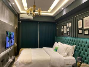 een slaapkamer met een groot bed met een groen hoofdeinde bij Du LoVeRe at Anderson Apartment in Lontar